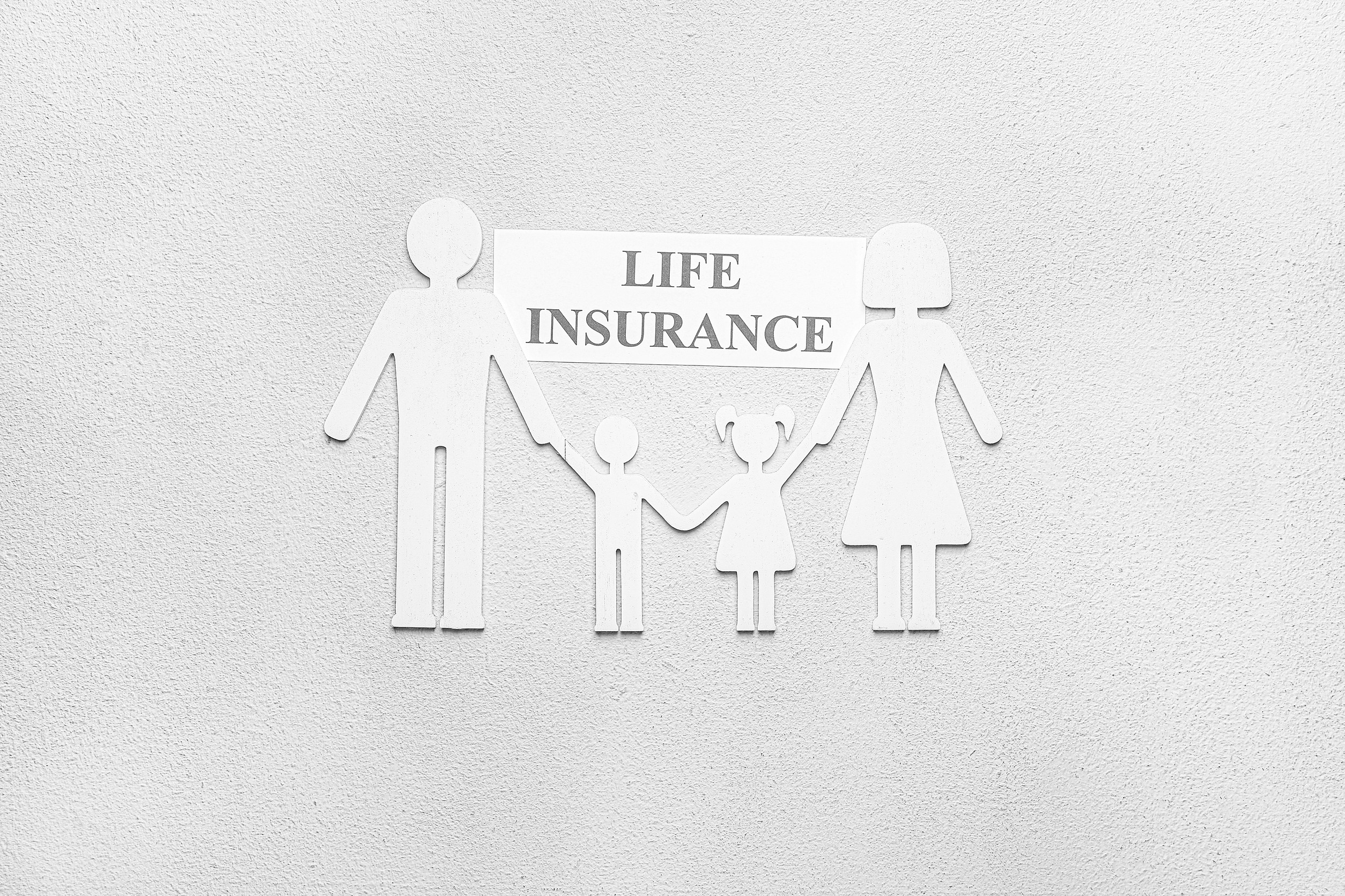 White cut-out figures of a family—two adults and two children—hold hands beneath a sign that reads 